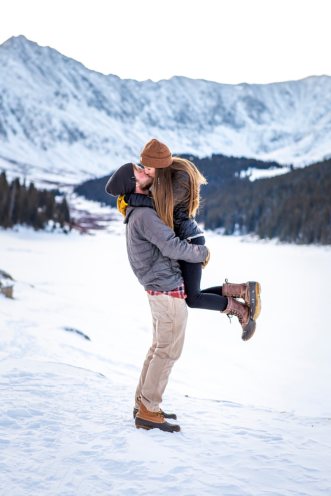 Man lifts woman for a kiss in Breckenridge, Colorado. Engagement Photo taken by Hillary Shedd Photography, Colorado Wedding Photographer. 