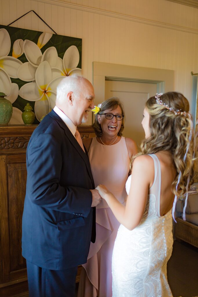 bride laughing with mom and dad before wedding